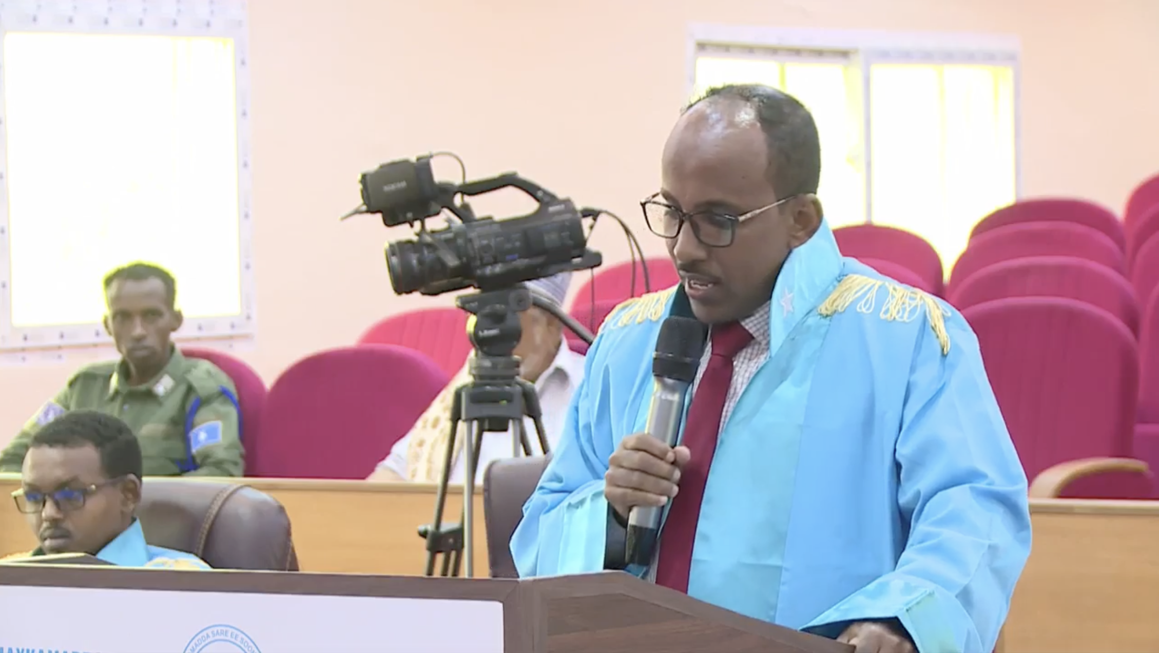 People and a camera in the courtroom during a session at the Somali Supreme Court on Wednesday, 18 September. | PHOTO/ Screenshot from a video provided by the Supreme Court.